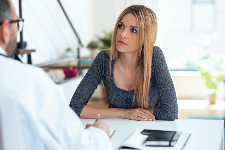 Mujer interesada en una consulta médica sobre liposucción y reducción de monte de Venus, valorando beneficios y opciones del procedimiento.