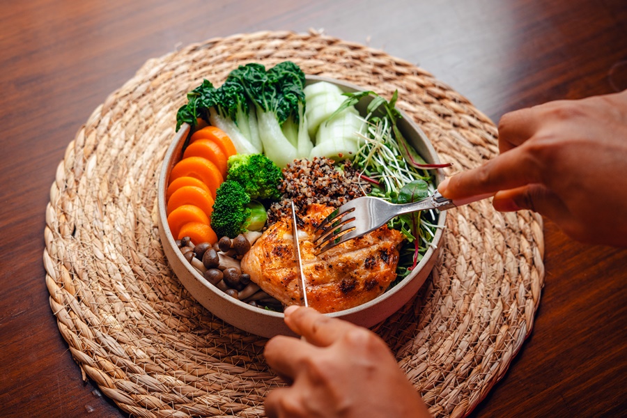 Plato saludable con salmón a la plancha, quinoa, verduras y setas, ejemplo de alimentación postoperatorio cirugía estética para favorecer la recuperación.