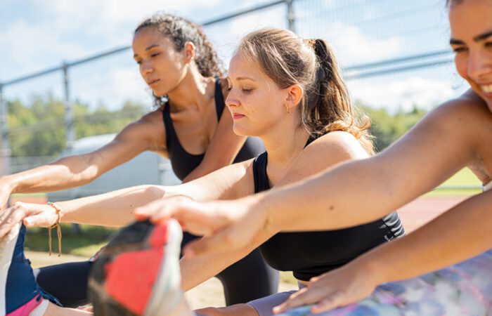 Grupo de mujeres realizando estiramientos al aire libre como ejemplo de ejercicio físico tras cirugía estética, destacando la importancia de una reincorporación progresiva y segura.