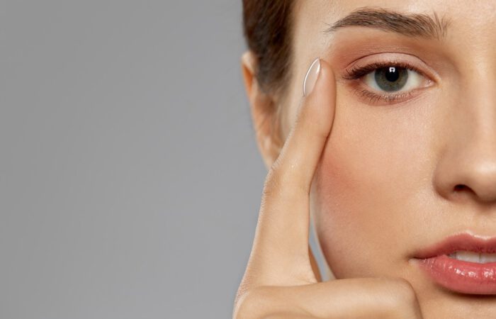 Primer plano del rostro de una mujer joven señalando la zona externa del párpado, con la piel tersa y el contorno ocular definido, ideal para ilustrar los efectos de una blefaroplastia láser sobre la mirada.