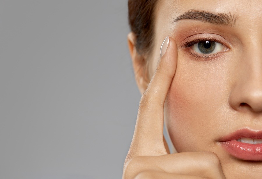 Primer plano del rostro de una mujer joven señalando la zona externa del párpado, con la piel tersa y el contorno ocular definido, ideal para ilustrar los efectos de una blefaroplastia láser sobre la mirada.