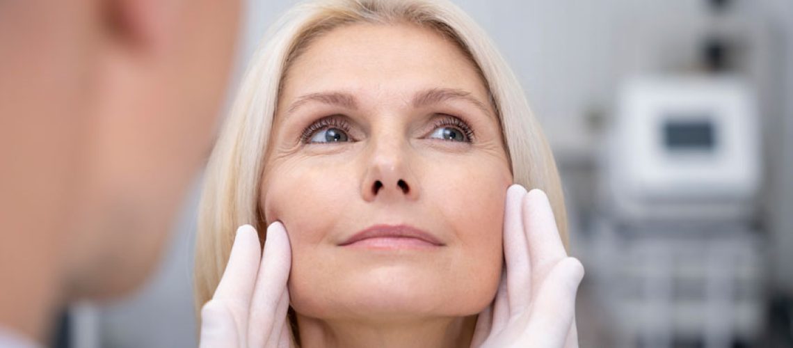 Una señora de avanzada edad recibiendo consulta por su médico estético para eliminar las arrugas de expresión.